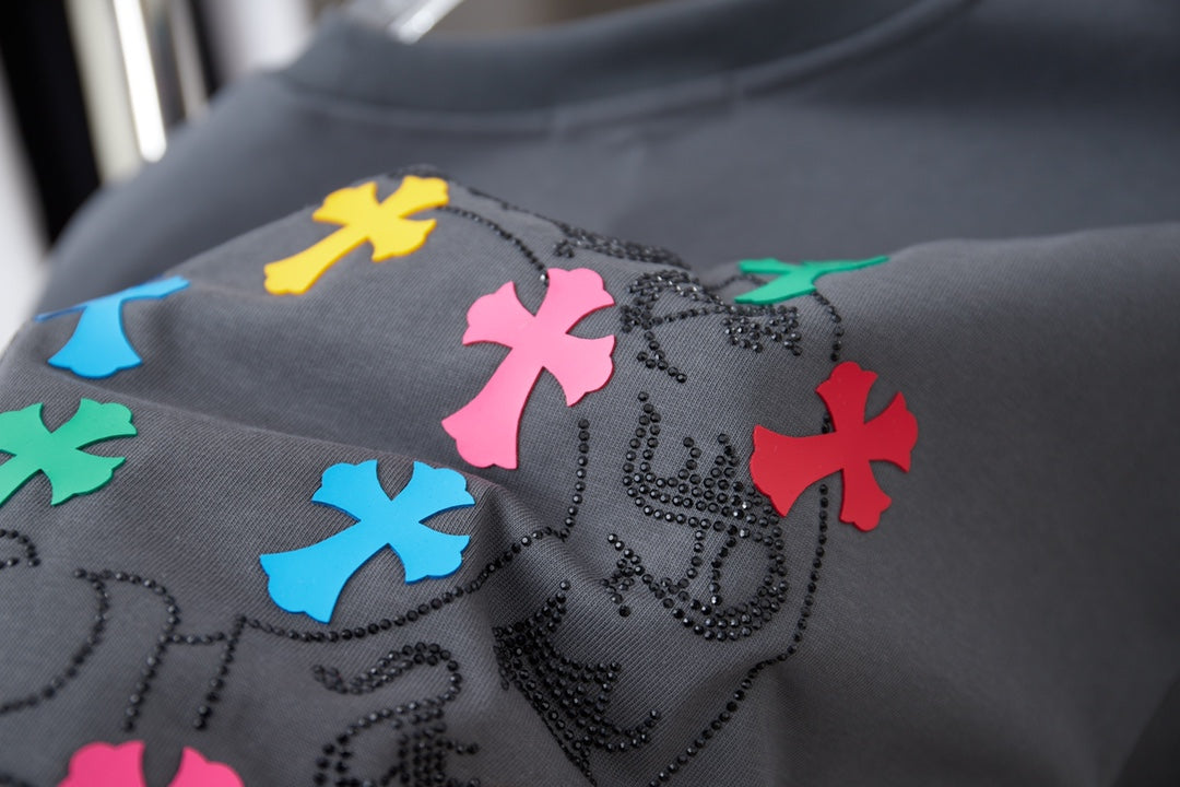 Gray T-shirt close-up of multicolor cross print with bead-like accents