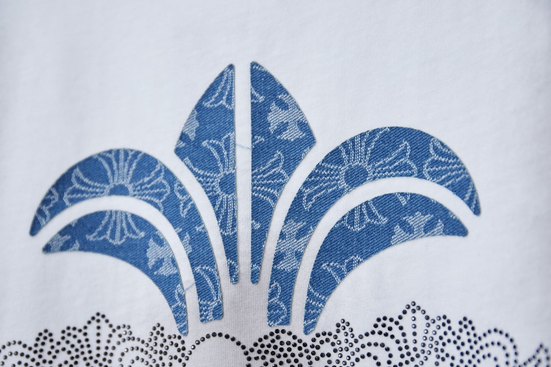 Chrome short T-shirt graphic closeup, blue fleur-de-lis with dotted accents