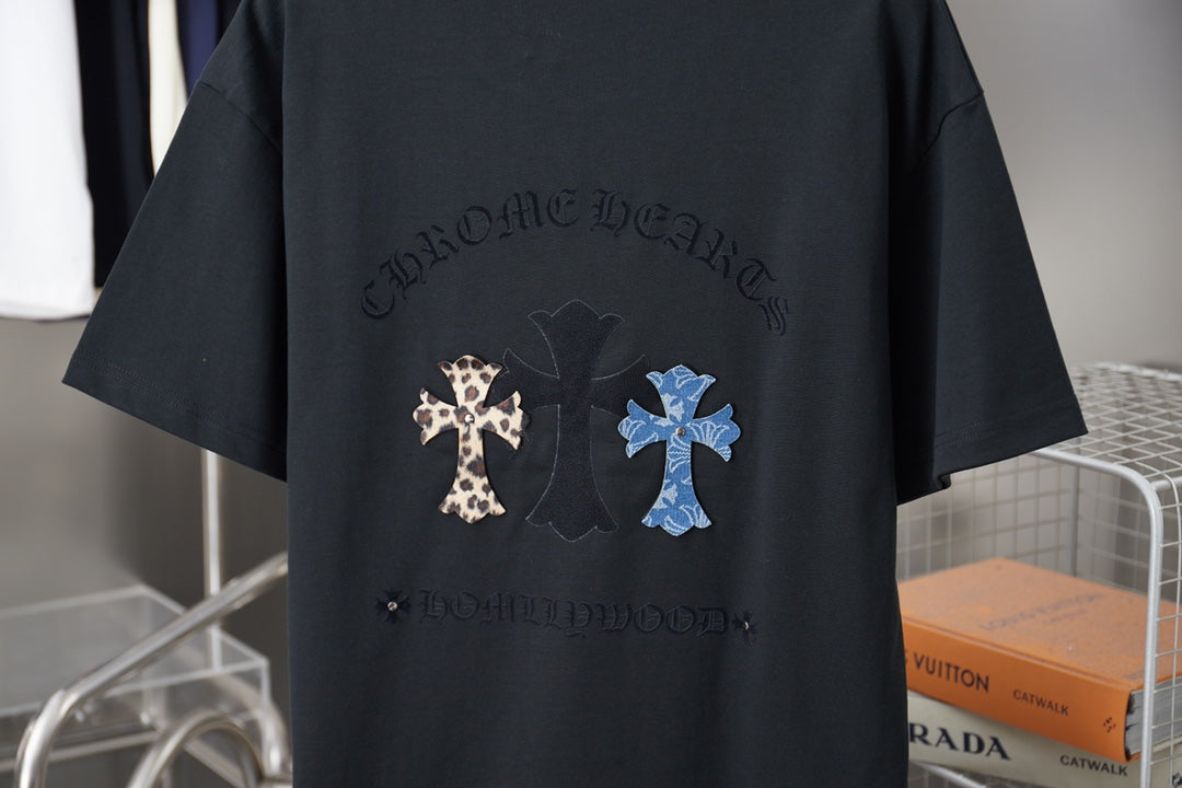 Black T-shirt back graphic with leopard and blue cross patches under dark text