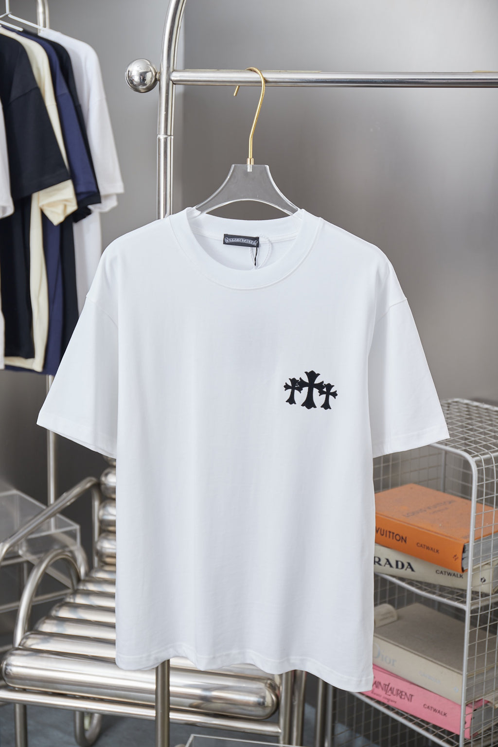 White short-sleeve T-shirt with small black graphic emblem on left chest