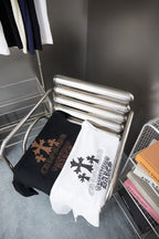Folded white and dark short-sleeve T-shirts with cross and star graphic designs