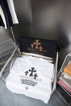 Folded white short-sleeve T-shirts with dark star and cross graphic on display