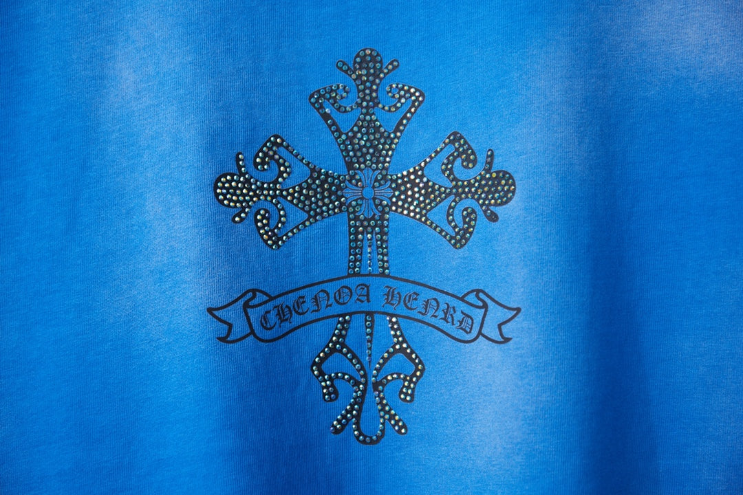 Blue T-shirt with dark rhinestone-style cross and banner emblem detail