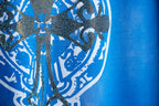 Blue T-shirt with rhinestone-style crest graphic and ornate floral details