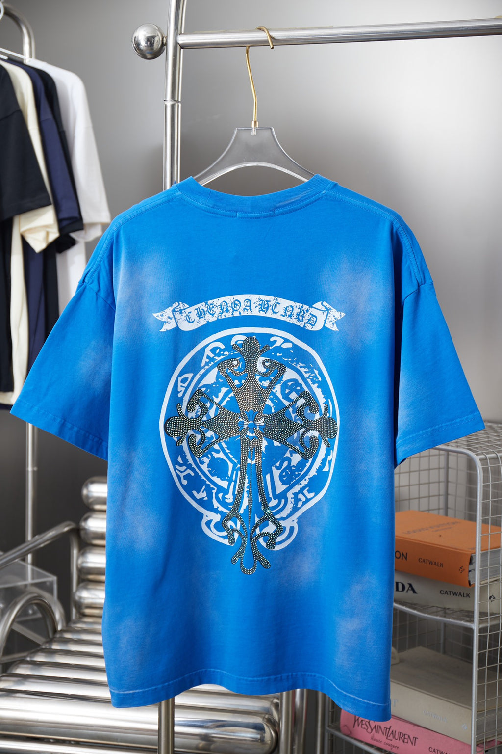 Blue short-sleeve T-shirt with large oval crest graphic centered on the back