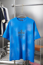 Blue short-sleeve T-shirt with small dark cross graphic on the chest