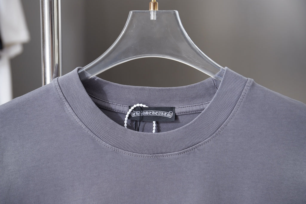 Dusty blue crewneck T-shirt neckline with ribbed collar and brand tag at center