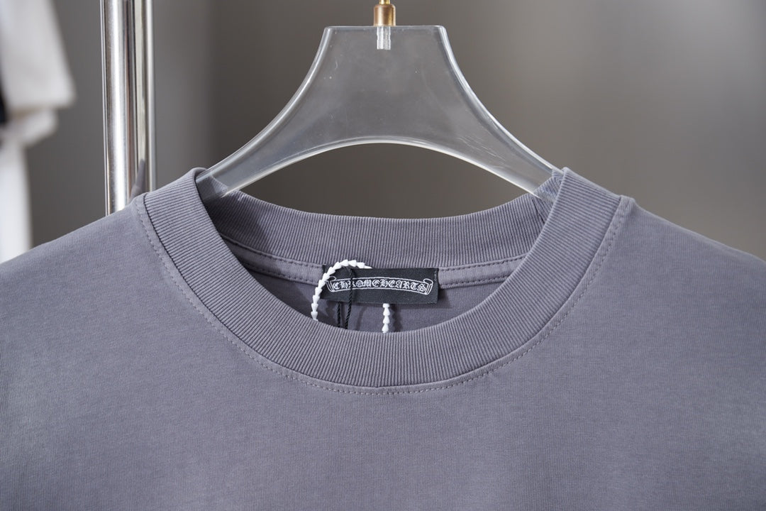 Dusty blue crewneck T-shirt neckline with ribbed collar and brand tag at center