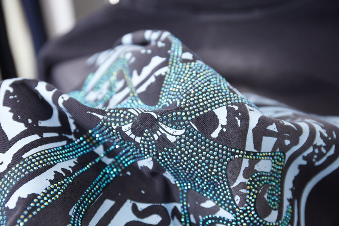 Close-up of rhinestone-style graphic on dark navy short-sleeve T-shirt