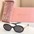 MiuMiu round sunglasses with black frames, gold accents, and dark lenses