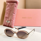 MiuMiu round sunglasses with champagne frames, gold accents, and dark lenses