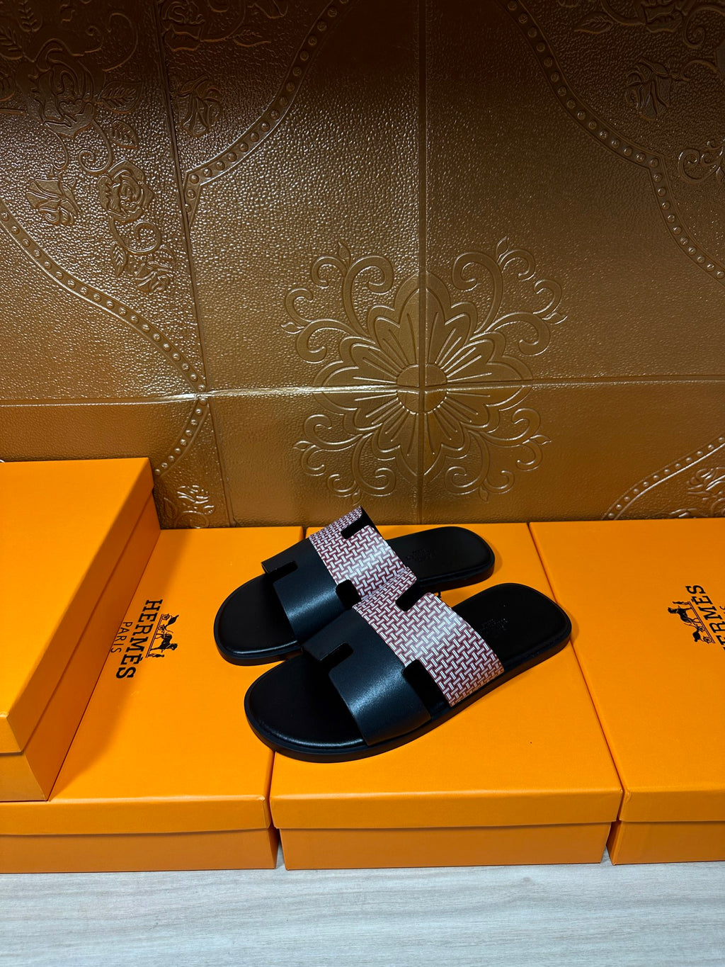 Hermes sandals with black slide sole and light patterned single strap detail, side view