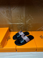 Hermes sandals with black slide sole and light patterned single strap detail, side view