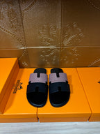 Hermes sandals with black slide sole and light patterned cross strap, open toe, pair