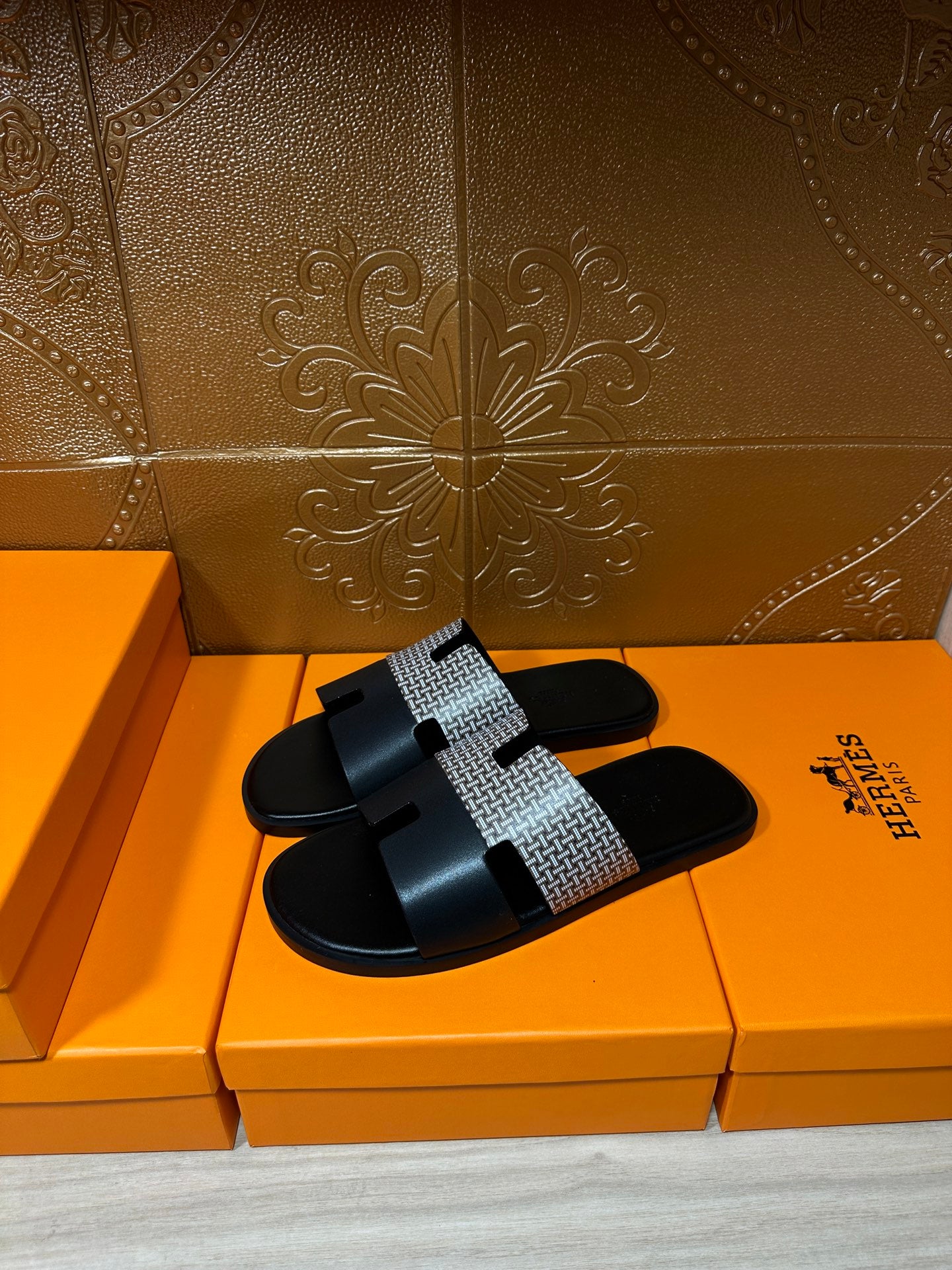 Hermes slide sandals, black leather-look slide with patterned gray strap and square buckle tab
