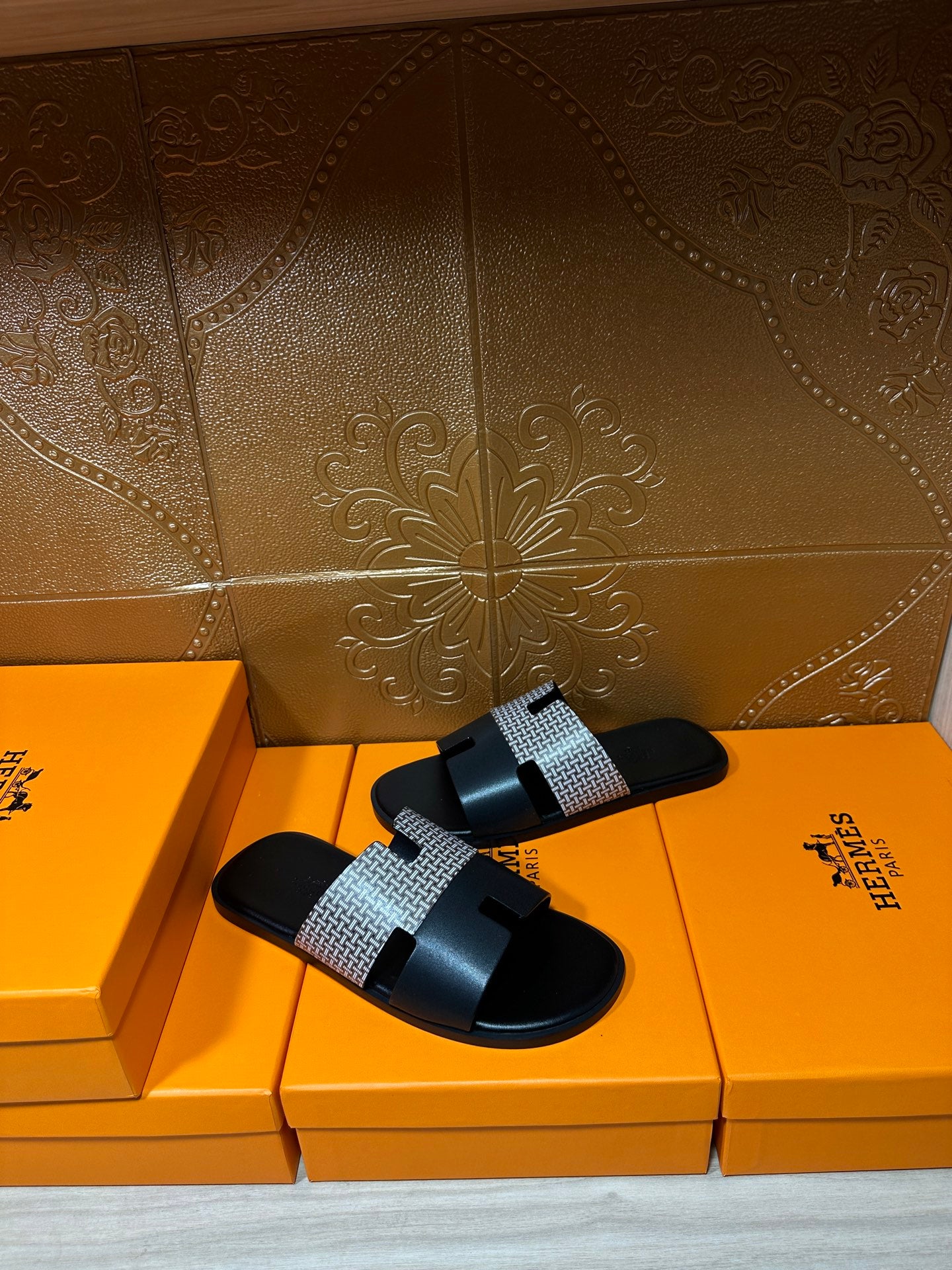 Hermes slide sandals with black footbed and textured gray strap, single pair view