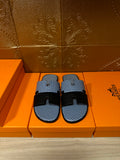Blue woven slide sandals with two black strap bands and black buckle, pair