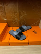 Blue woven slide sandals with black strap bands and buckle, pair front angle