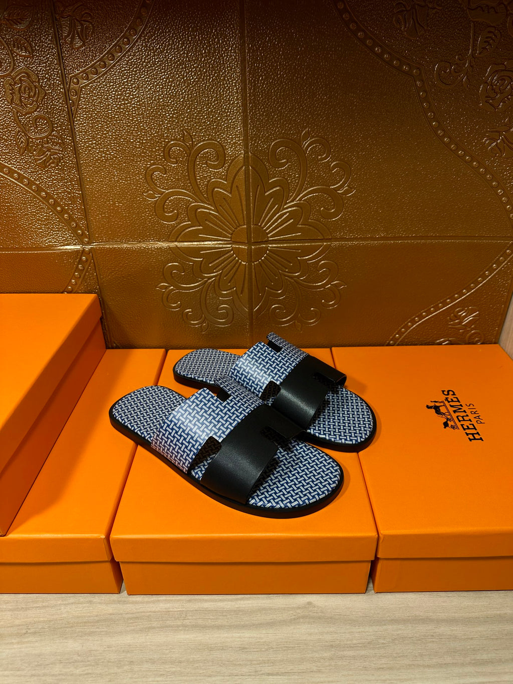 Blue woven slide sandals with black cross straps and black buckle, pair side view