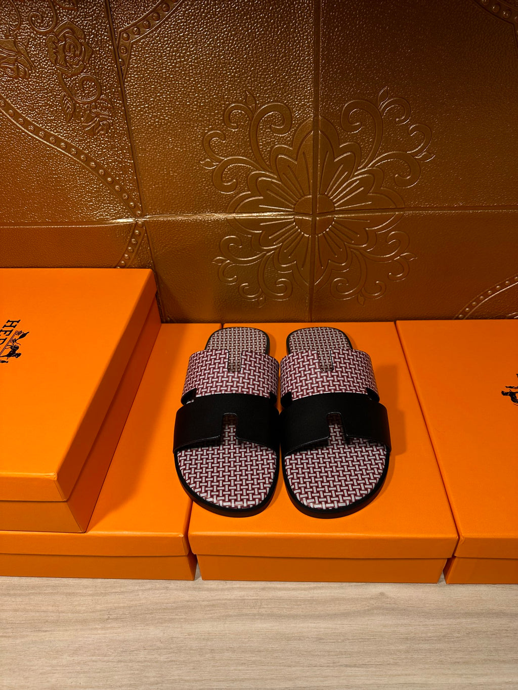Slide sandals with pink textured upper and black wide buckle strap; pair of shoes