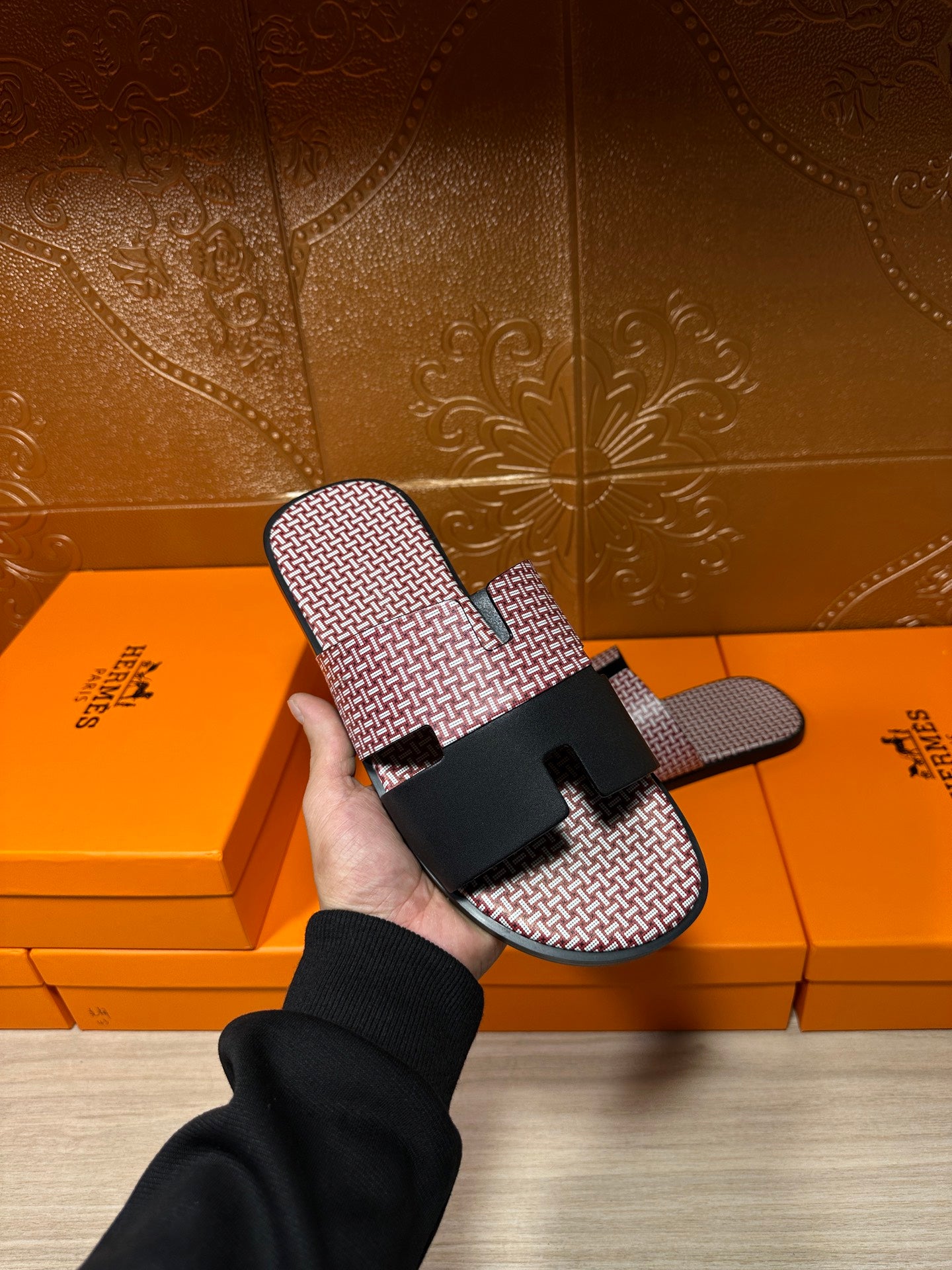 Pink textured slide sandals with black buckle strap shown in hand; open-toe