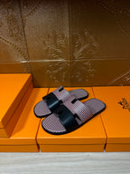 Slide sandals with pink textured fabric straps and black buckle detail; single shoe
