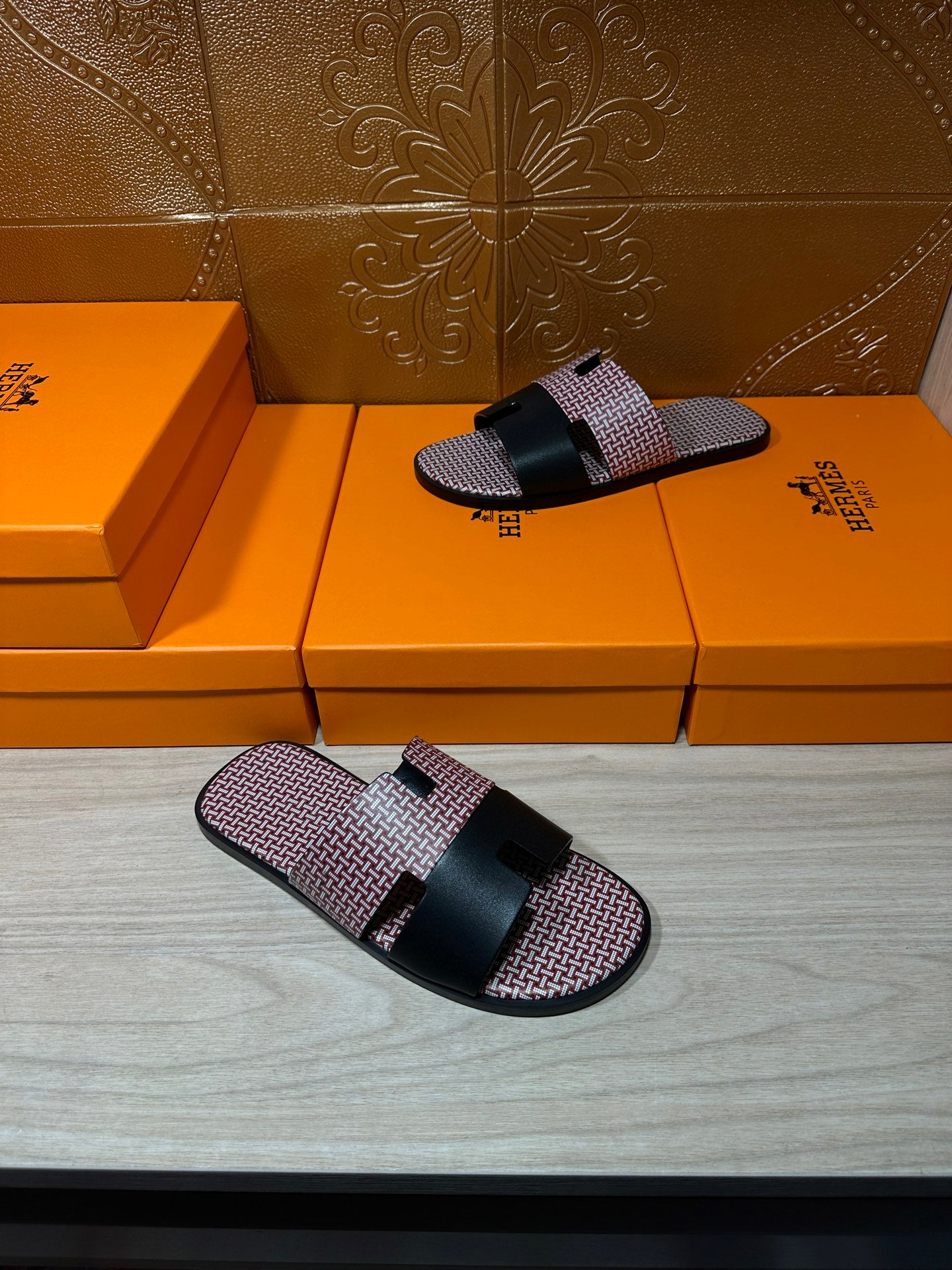 Slide sandals with pink textured fabric footbed and black buckle strap; one shoe
