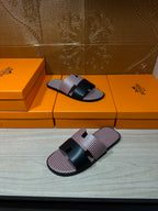 Slide sandals with pink textured upper and black center strap; open-toe slip-on