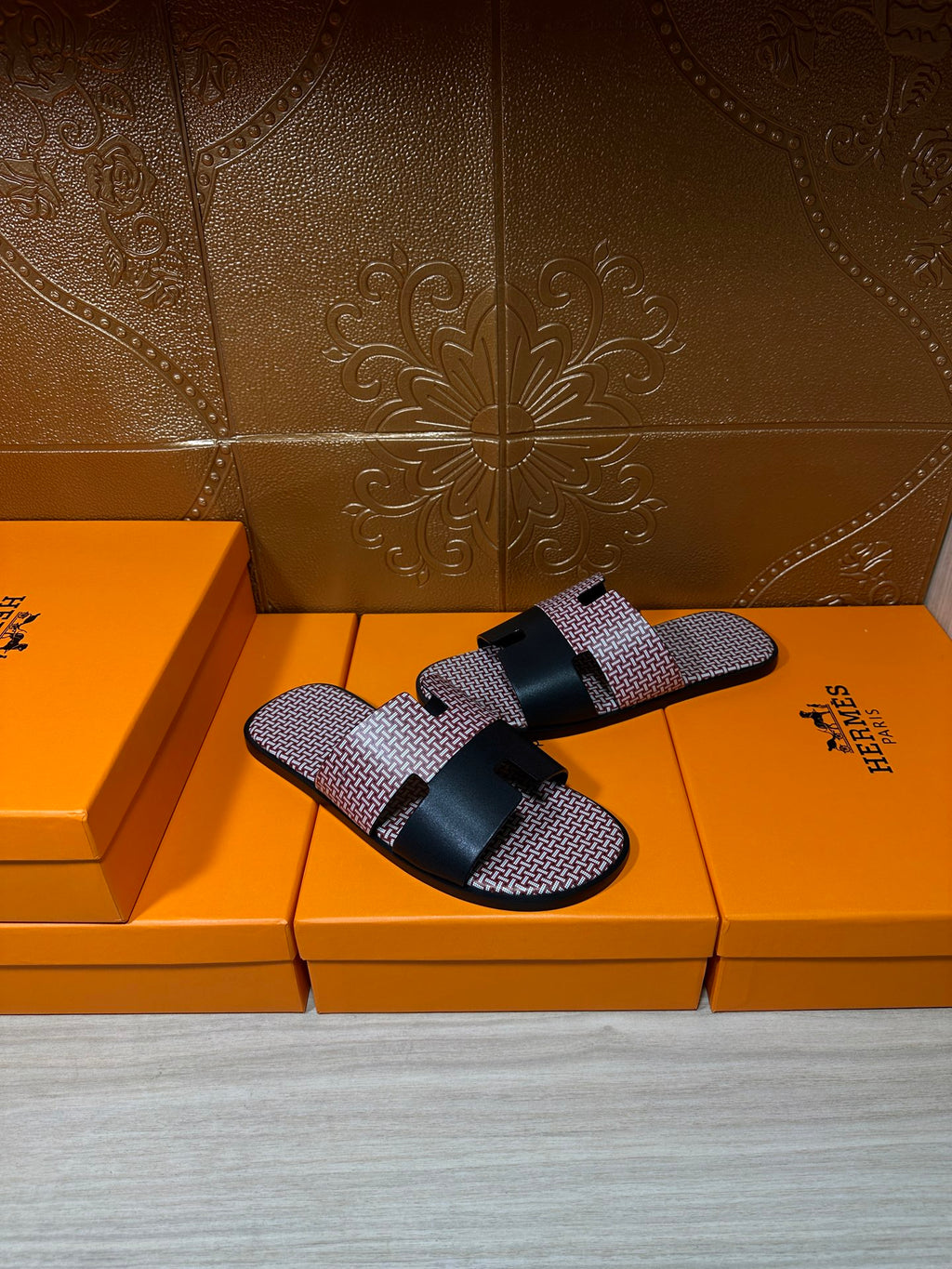 Slide sandals with pink textured upper and black leather-look strap across the top