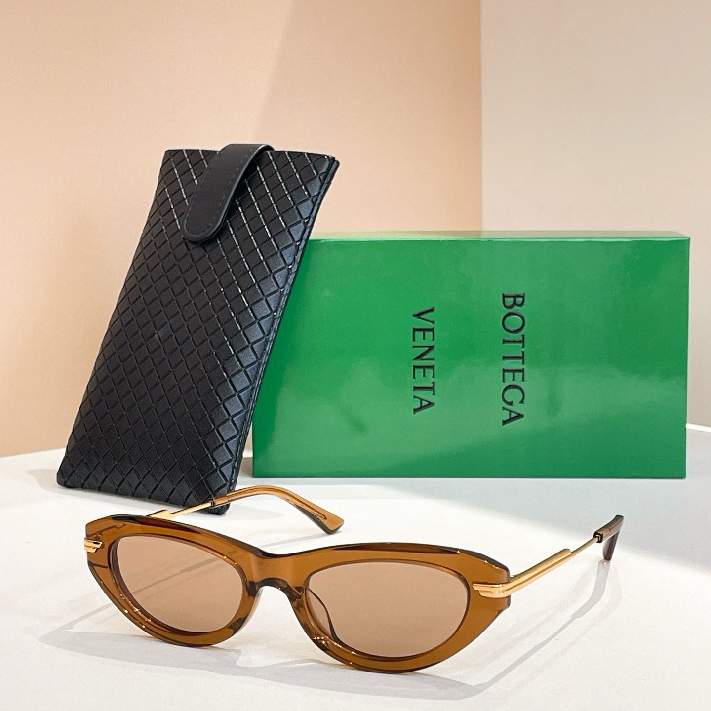 Brown-tortoise cat-eye sunglasses with gold-tone temples and brown lenses, with black case