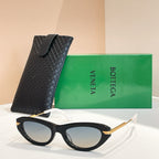 Black cat-eye sunglasses with gold-tone temples and blue-tinted lenses, with black case