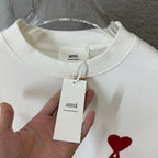 White crewneck sweatshirt with fabric tag at collar and red heart A logo