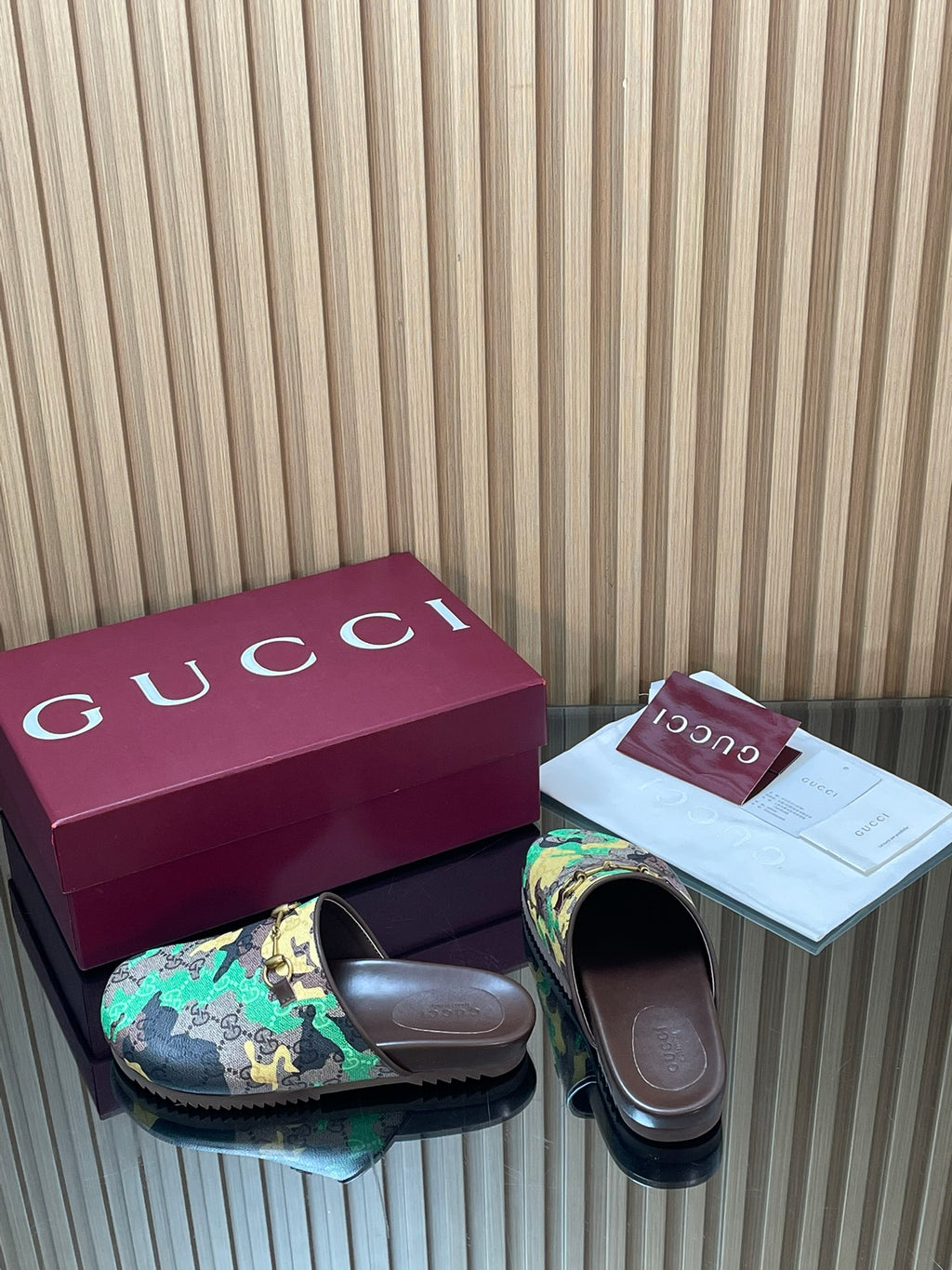 Gucci slide sandals with multicolor logo upper and dark slides, side by side