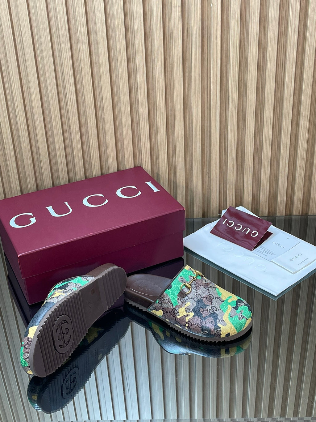 Gucci slide sandals close-up of sole edge, multicolor top with gold buckle