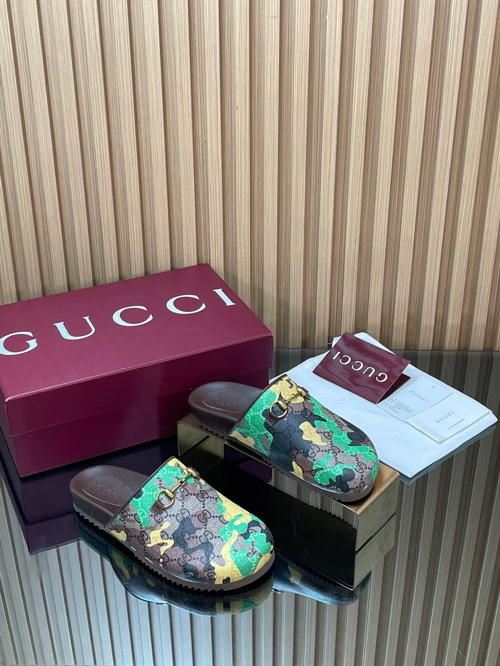 Gucci slide sandals, multicolor logo print with dark base and gold buckle strap