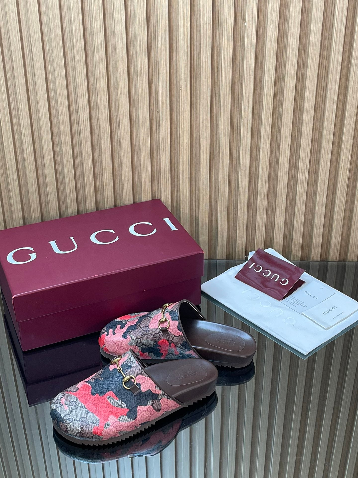 Gucci slide sandals, pink-and-black patterned top with gold-tone buckle and padded footbed