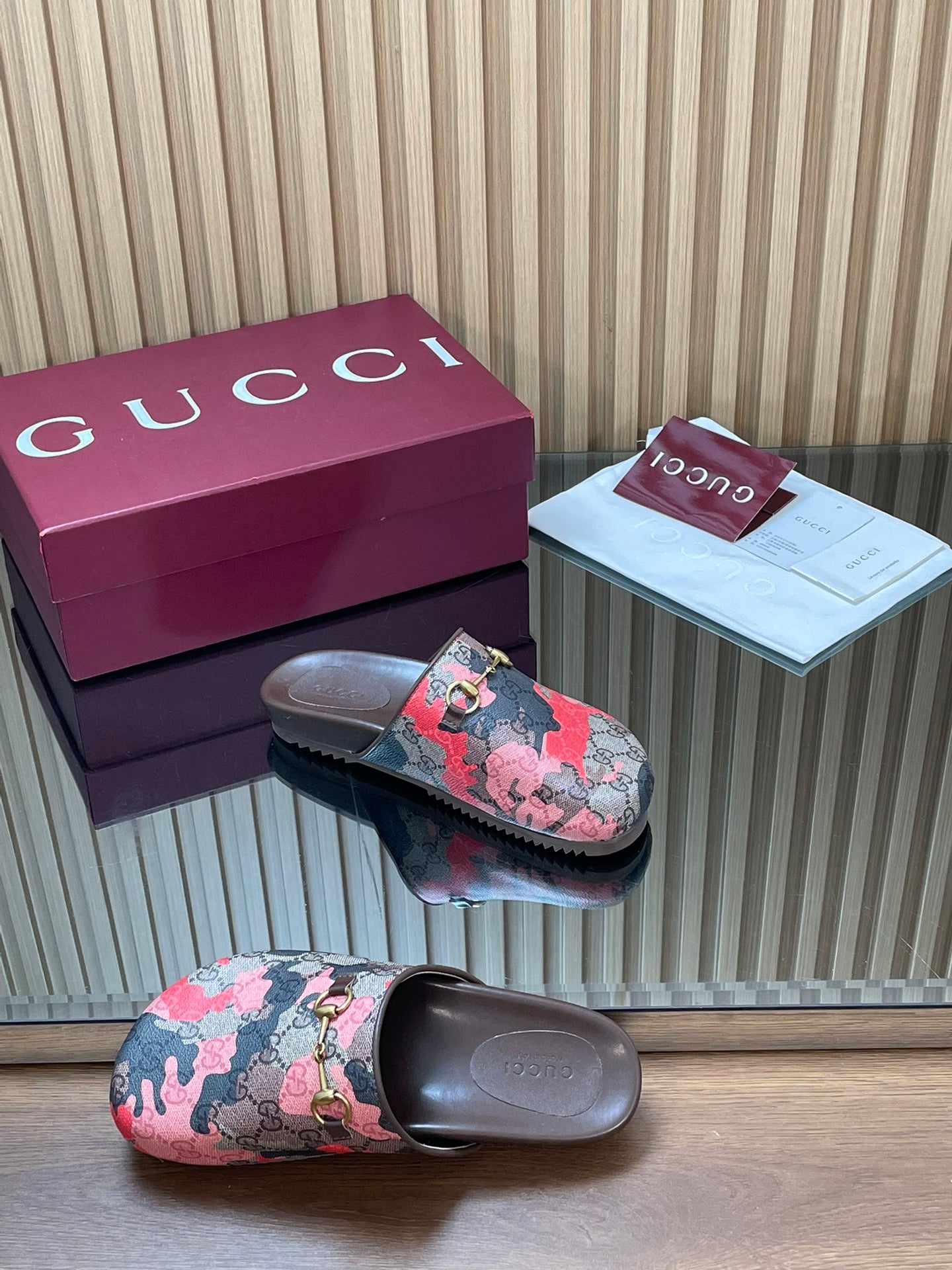 Gucci slide sandals, pink-and-black patterned upper with gold-tone buckle on dark footbed