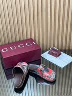 Gucci slide sandals with pink-and-gray patterned bands and metal logo buckle, open toe