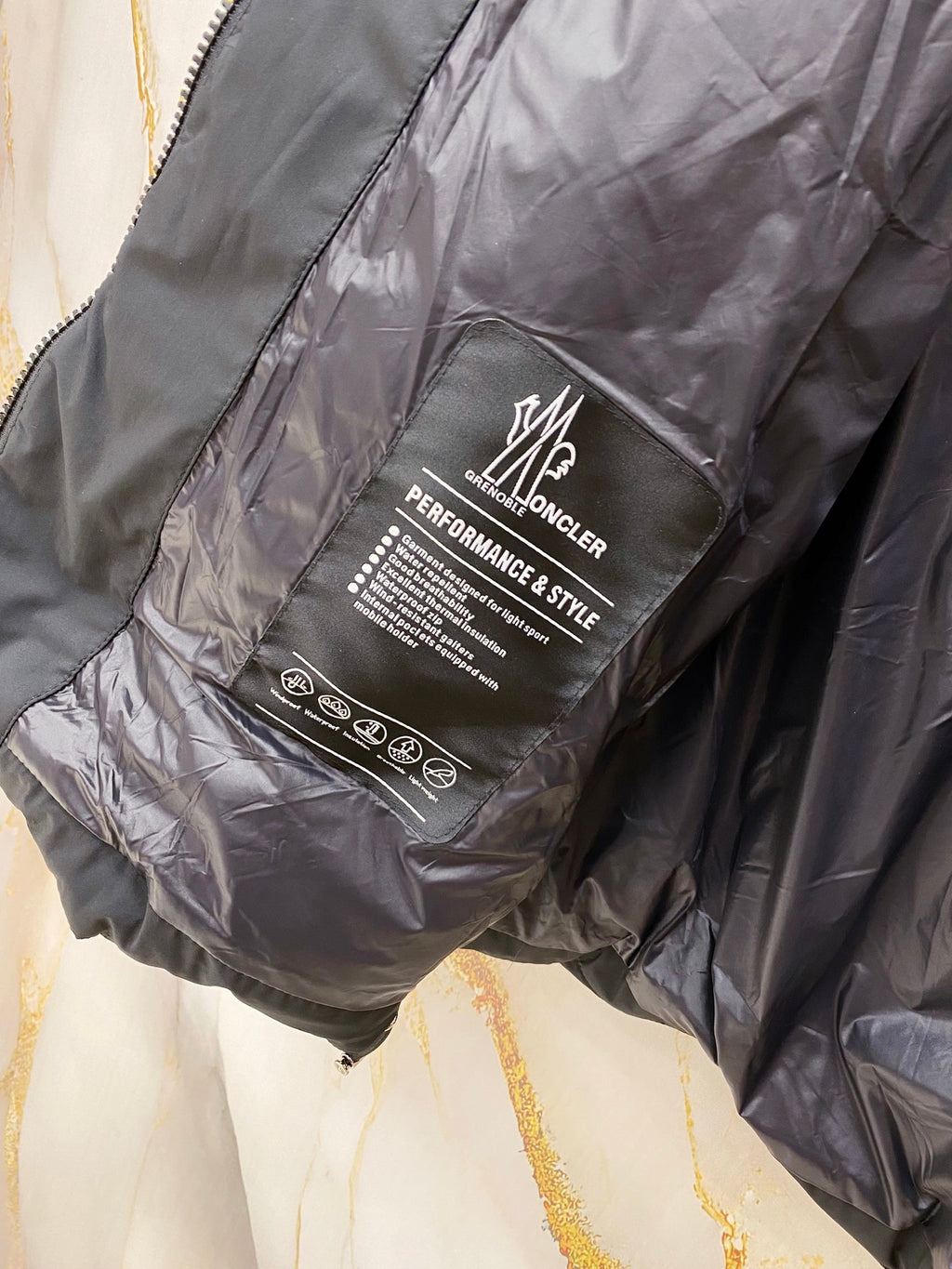 Long jacket label reading MONCLER PERFORMANCE STYLE, dark