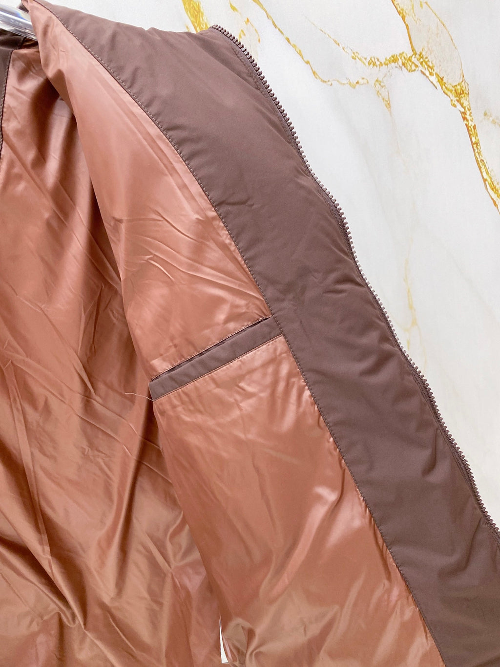Moncler puffer jacket lining detail, brown quilted panels and seams.