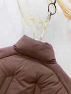 Moncler puffer jacket hood and collar detail, dark brown padded fabric.