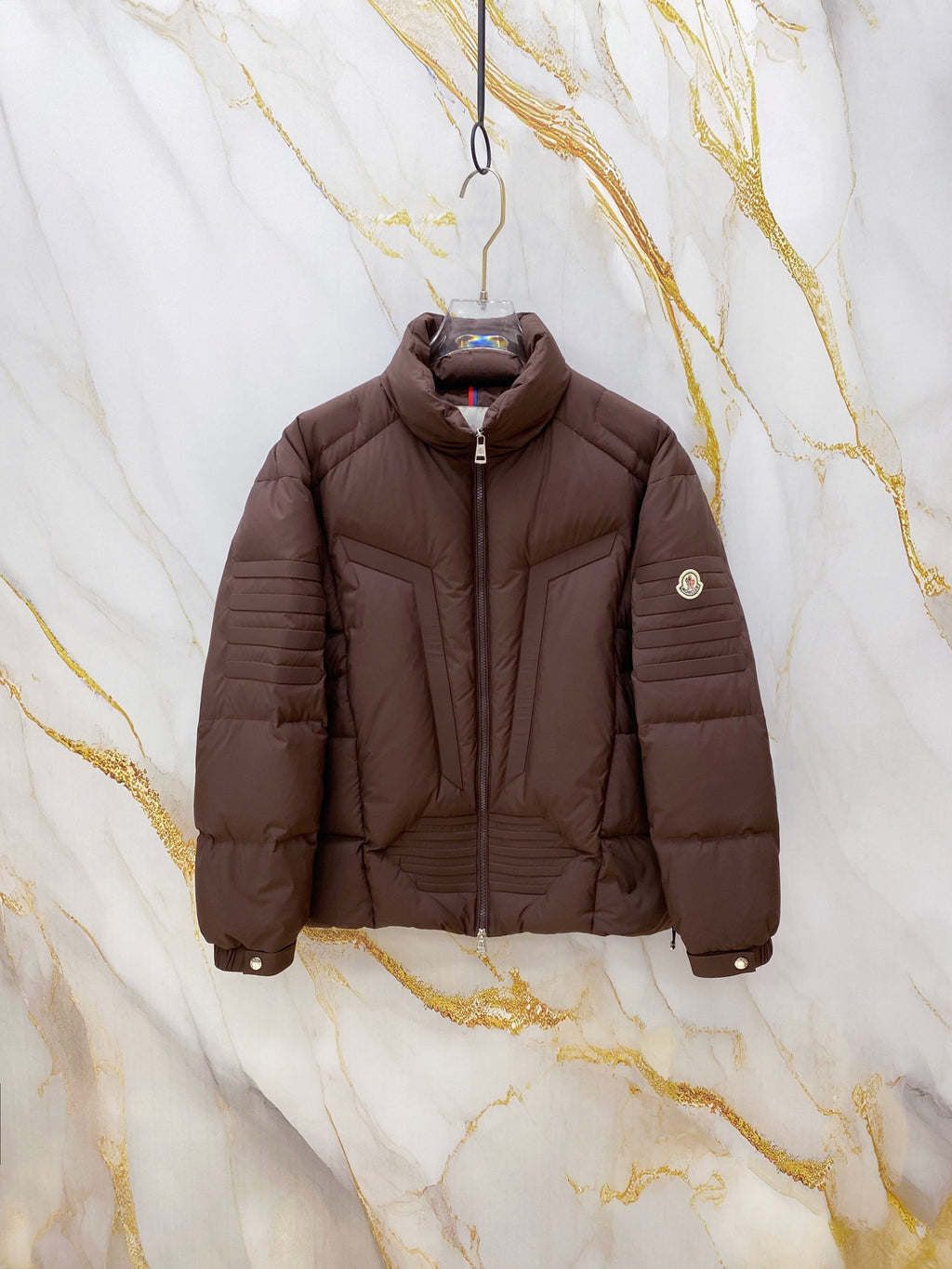 Long Moncler puffer jacket, dark brown, front zip and standing collar.
