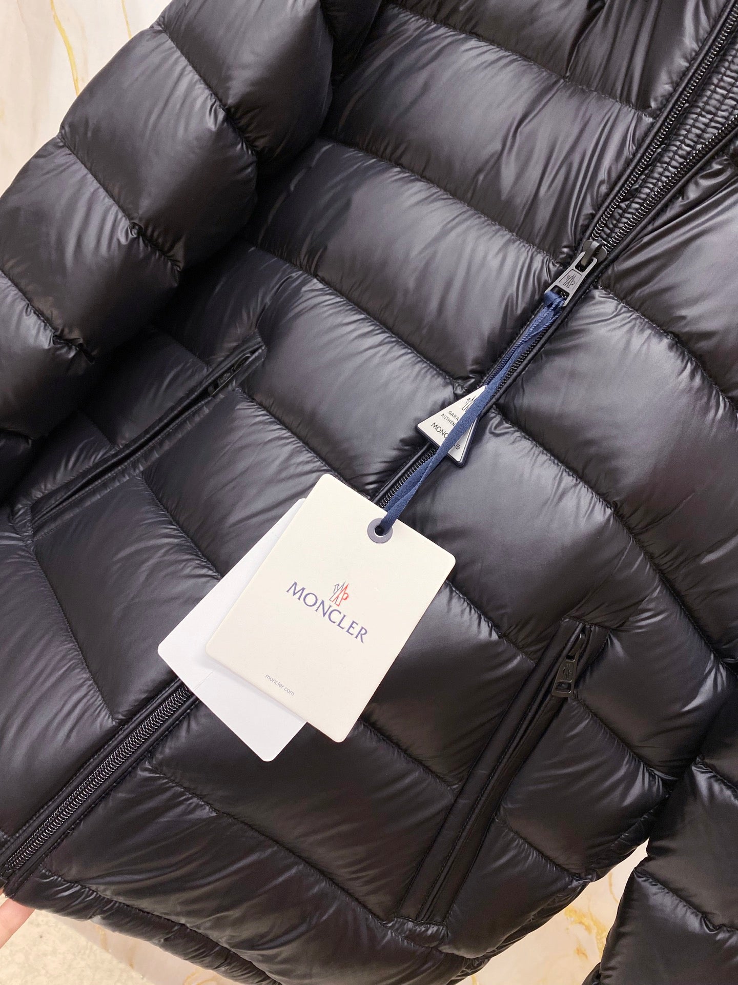 Quilted puffer jacket front with zipper and hanging product tag