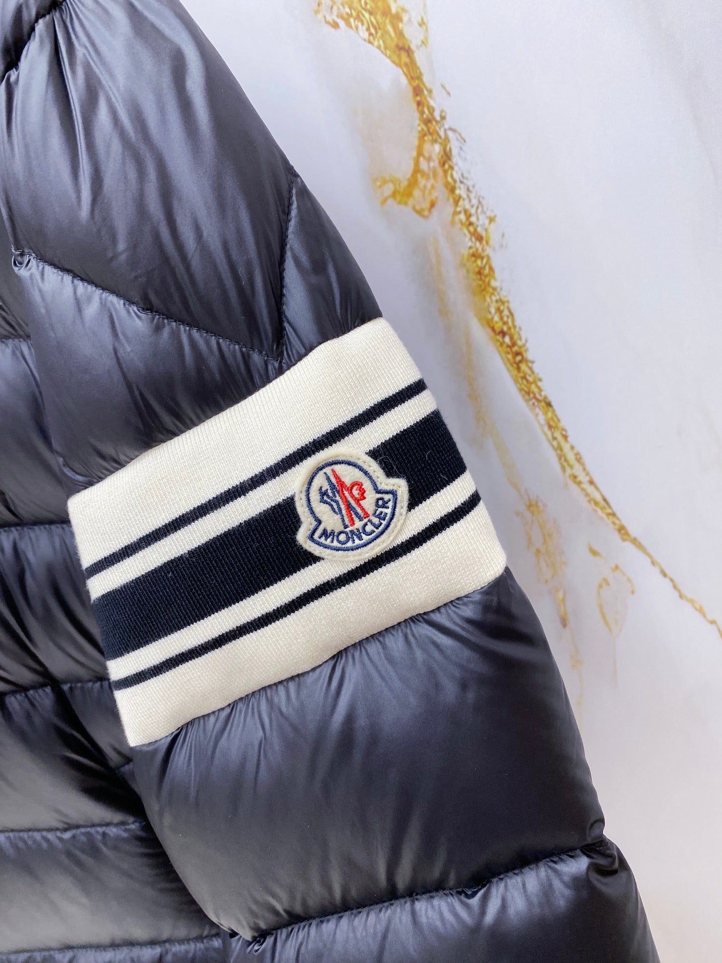 Long puffer jacket wrist band with Moncler logo patch and striped trim