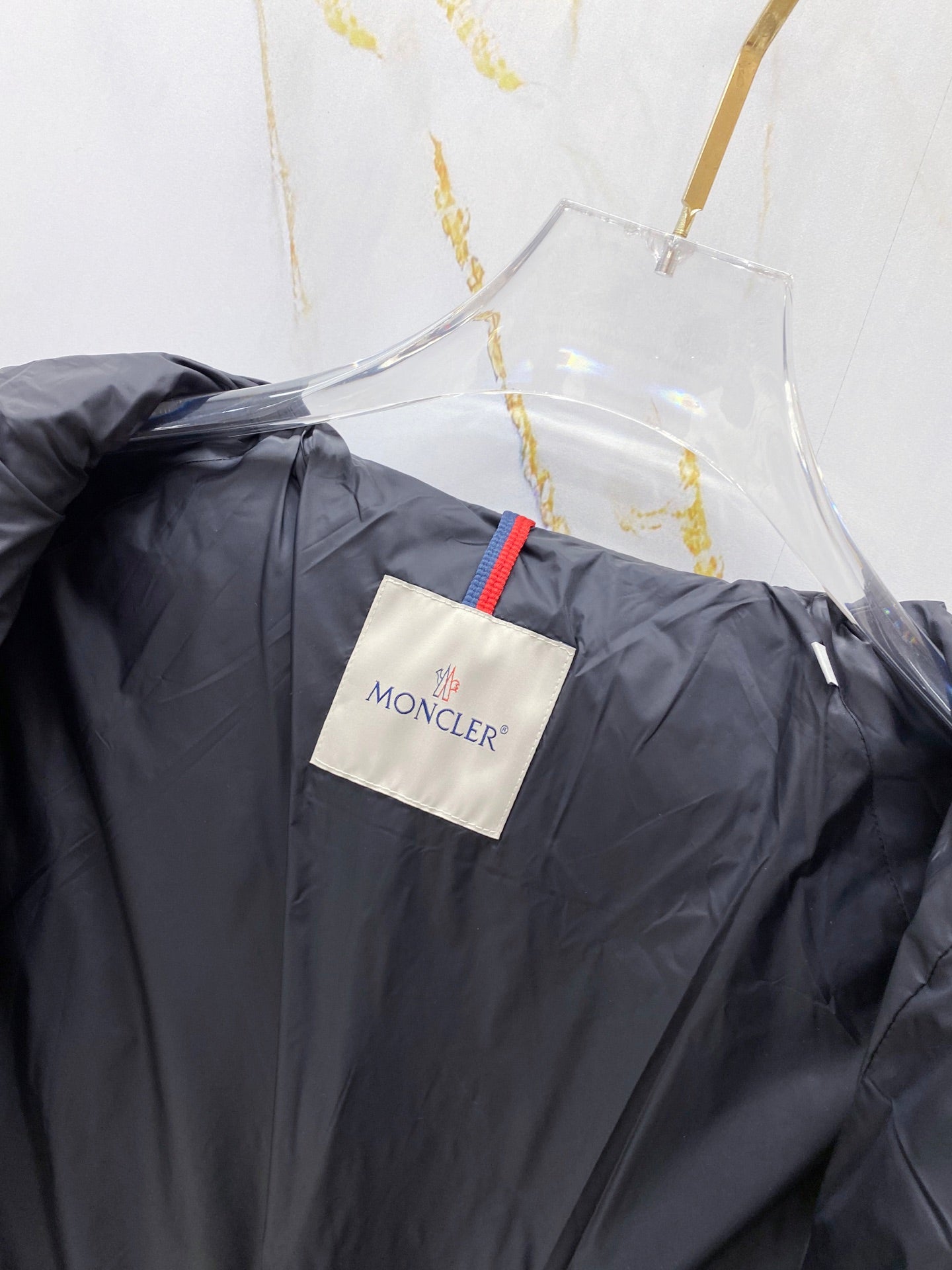 Moncler long puffer jacket back neck close-up, dark navy with Moncler tag