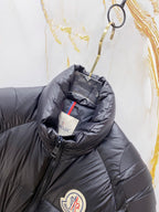 Moncler long puffer jacket close-up, dark navy hooded collar and logo badge