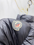 Moncler long puffer jacket shoulder close-up, dark navy with circular logo patch