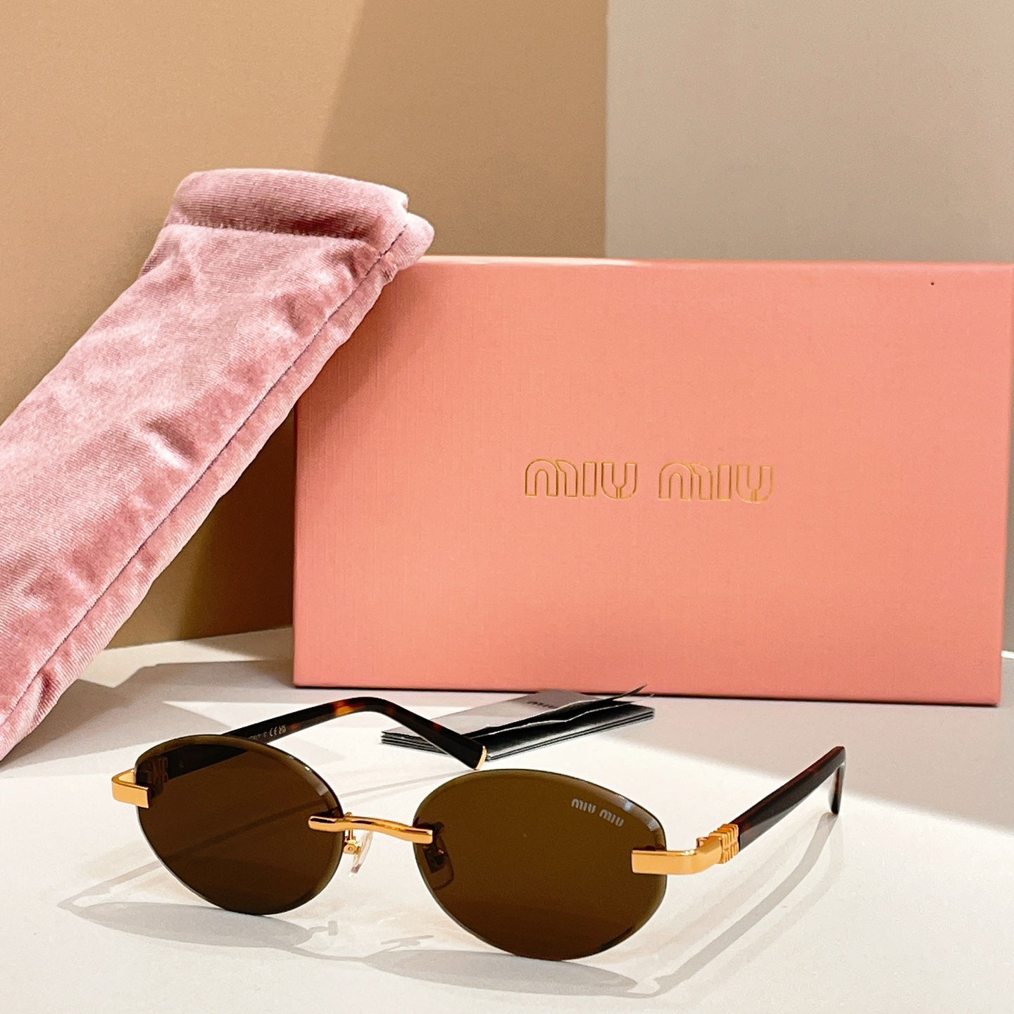 Round sunglasses with dark-brown lenses and gold-tone frames, black arms