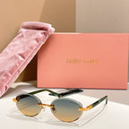 Round sunglasses with amber-orange lenses and green-tinted arms, gold-tone frames