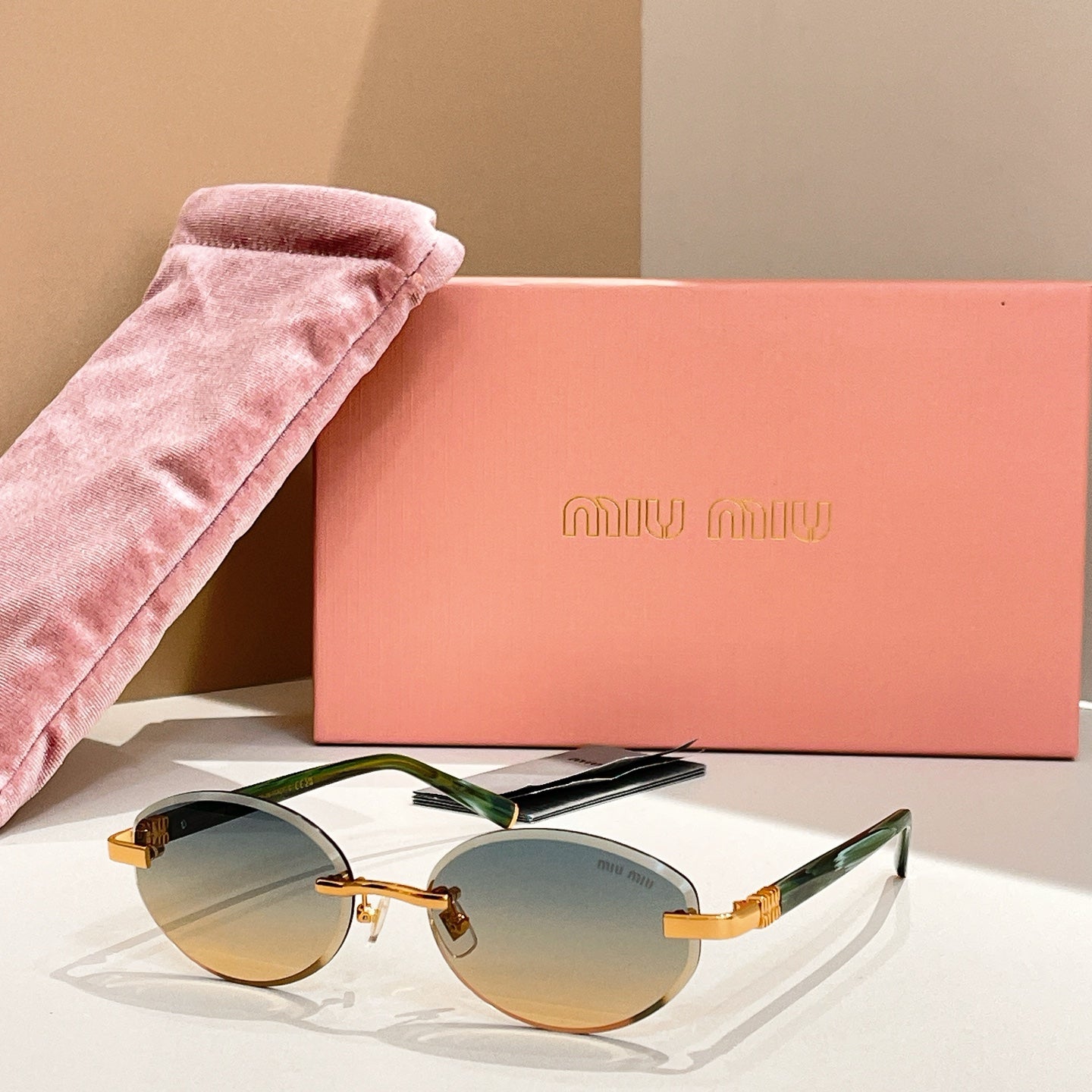 Round sunglasses with amber-orange lenses and green-tinted arms, gold-tone frames